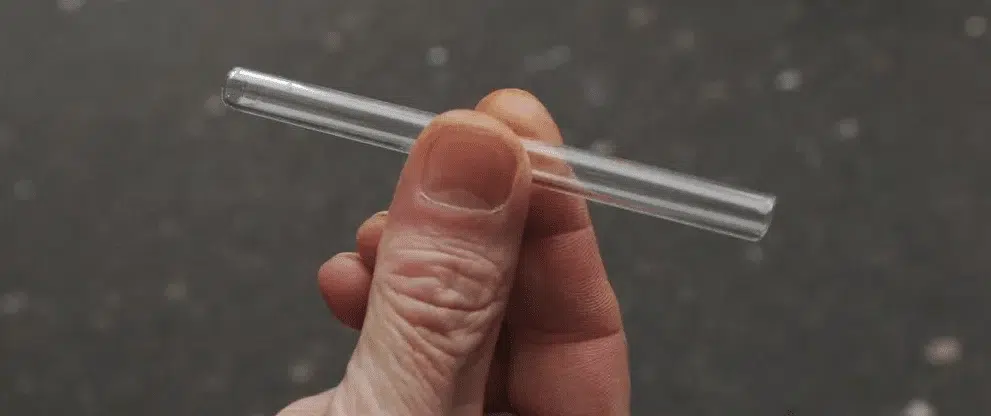 image of a man holding a glass meth pipe stem