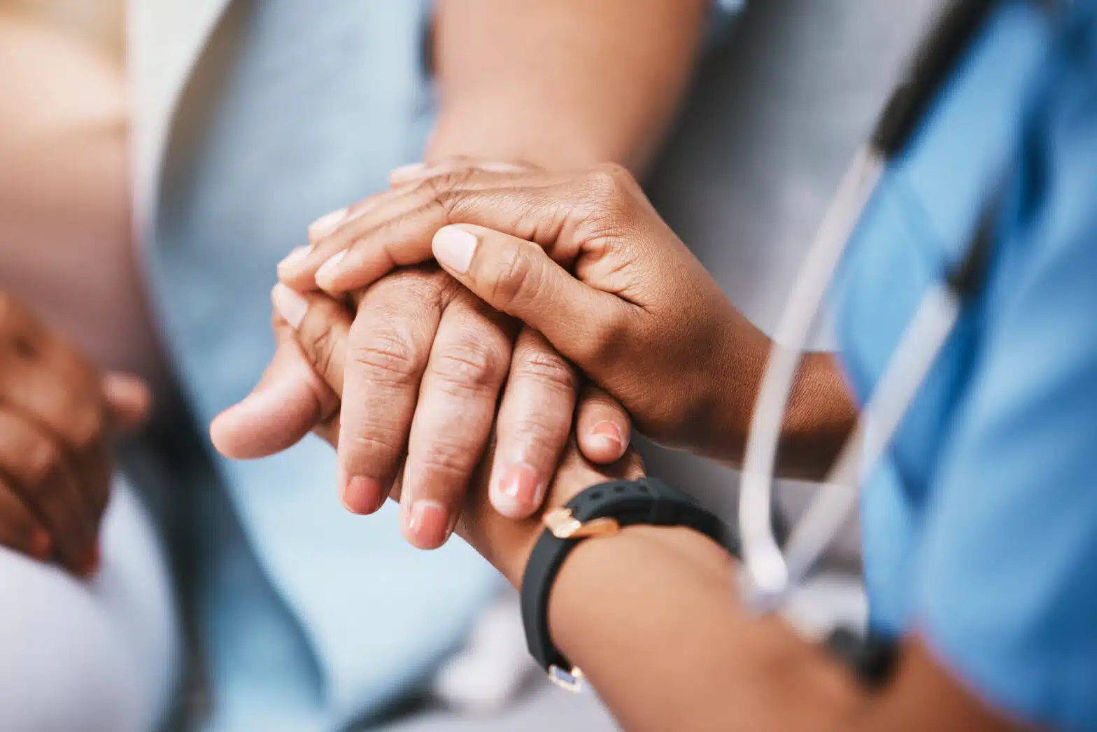 A close-up image of a doctor clasping a patient's hand between theirs - Is Addiction Recognized As A Disability