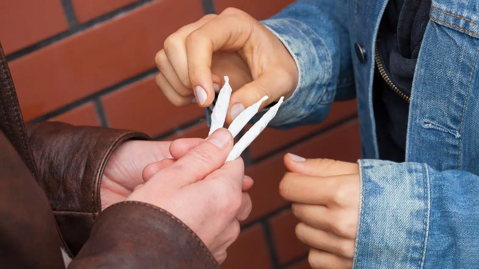 A teen take a joint from his friend's hand - Teen Marijuana Use Linked To Mental Health Risks
