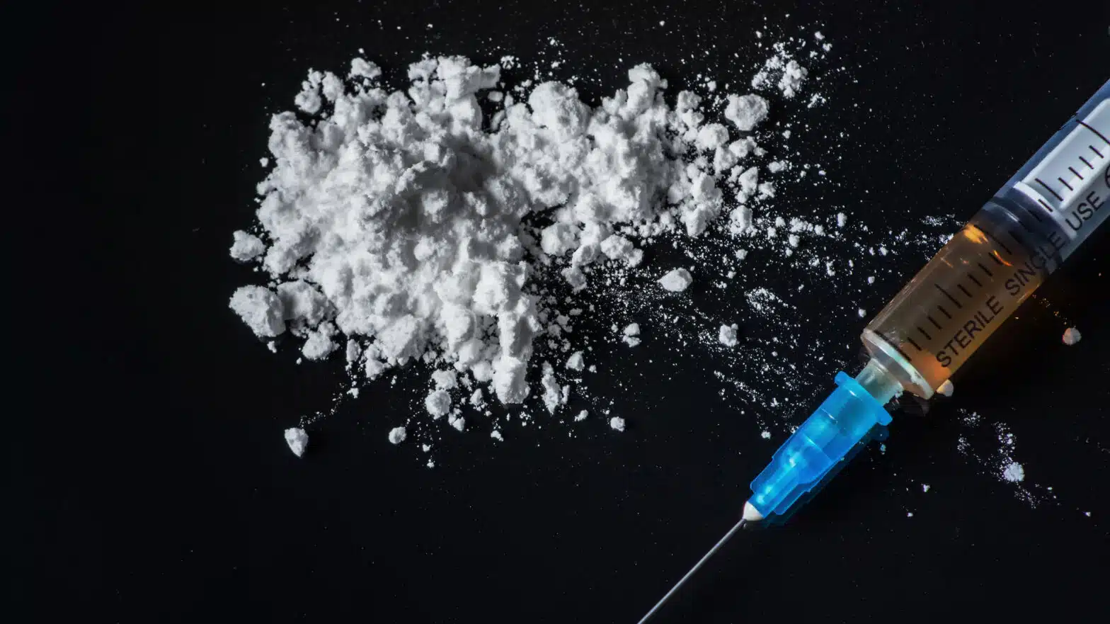 A needle lays next to a pile of white powder - Massachusetts Uses States’ Rights To Argue For Safe Injection Sites
