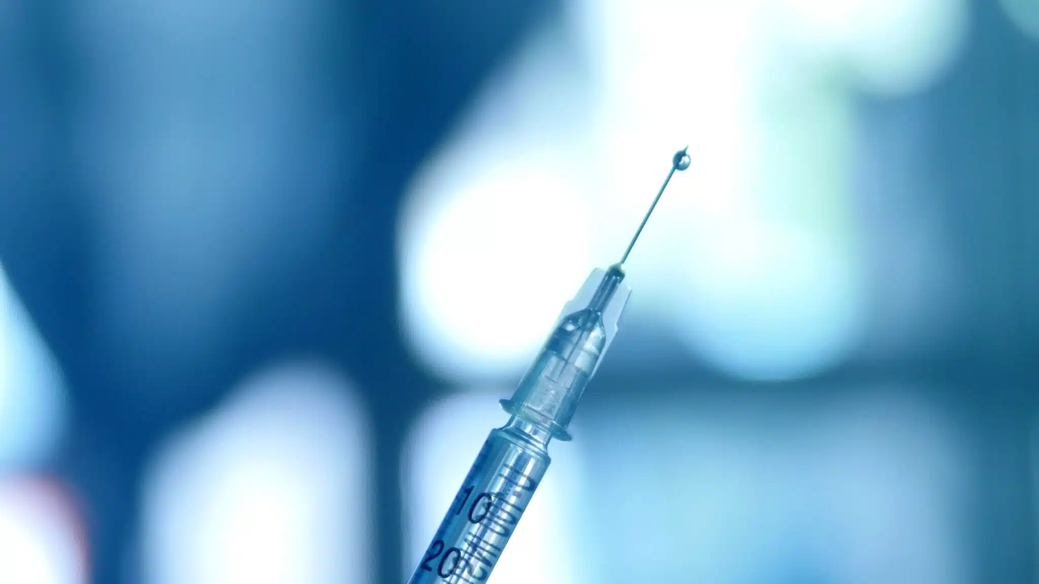 A close up on a needle with with a liquid droplet coming out - Common Health Complications From IV Drug Use