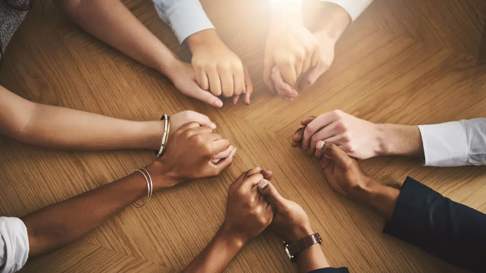 An overhead view of multiple people holding hands - Finding Family Support Groups And Other Addiction Resources
