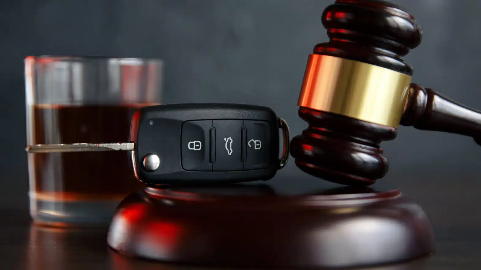A car key sits between a glass of liquor and a gavel - Will Going To Treatment Reduce Charges For A DUIDWI
