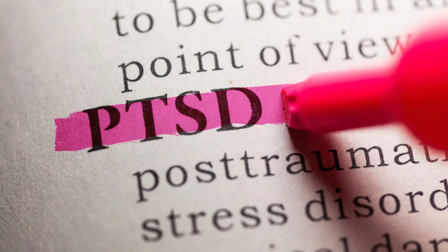 A dictionary page with a person highlighting the term PTSD - Post-Traumatic Stress Disorder (PTSD) Overview & Treatment