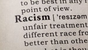 A dictionary page with the definition of Racism - The Impact Of Racism On Mental Health